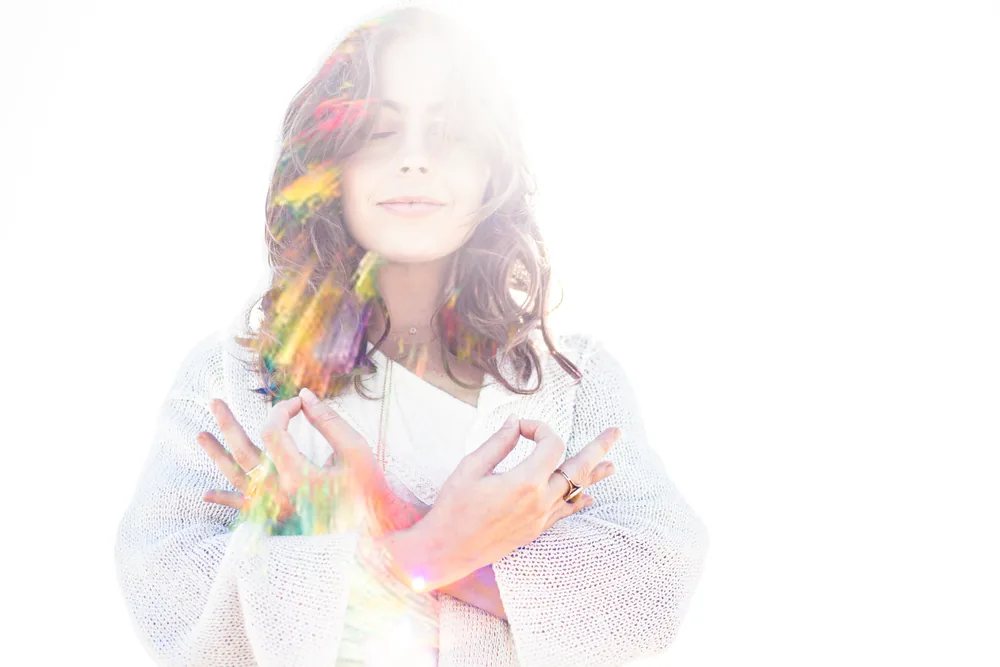 Reiki-Infused Meditations cover art: a woman with her eyes closed and hands crossed over her chest in bright light