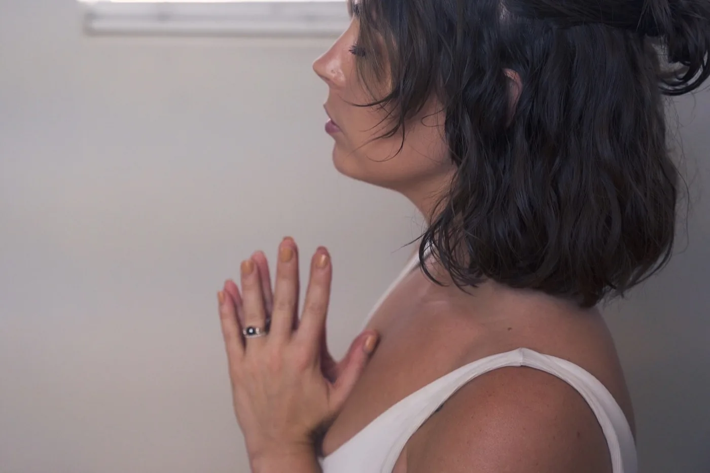 Hands resting at the heart in a Reiki self practice at the Word of Mouth studio