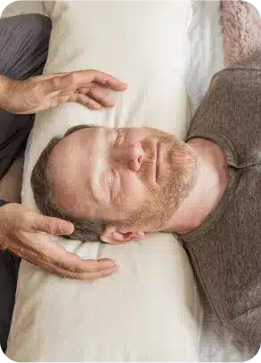 Reiki practitioner resting hands lightly near the face, showing what happens during a reiki session at the Word of Mouth Melrose studio in West Hollywood